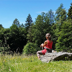 Naturlandschaft mit sitzender Person als Sinnbild für geistige Entwicklung und die Überwindung von Bindungen.