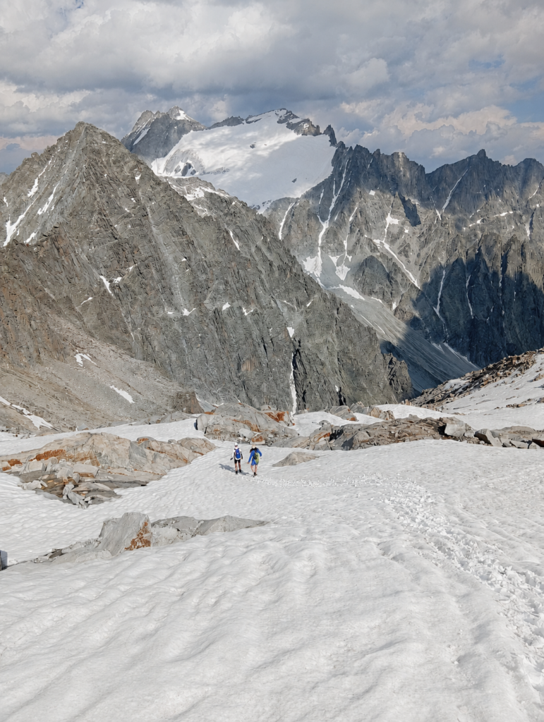 Schneebedeckter Hochgebirgsweg mit Bergsteigern vor einem mächtigen Gipfel als Sinnbild für Satya, die Wahrheit im Raja-Yoga.