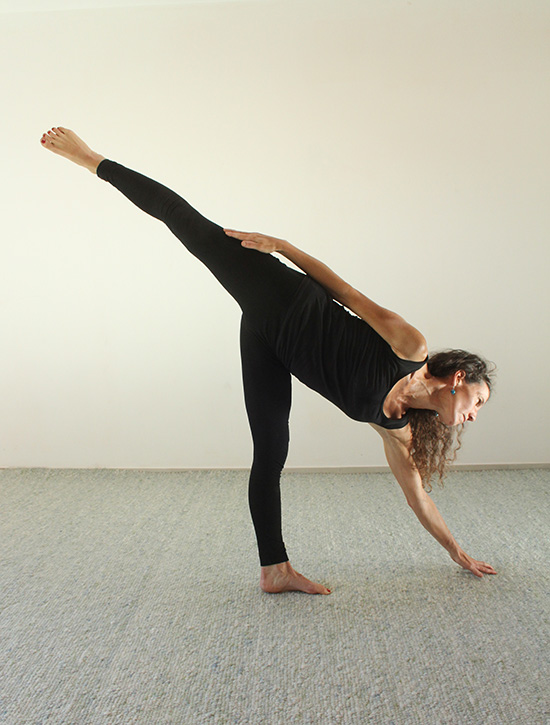 Frau im seitlichen Dreieck – die geöffneten Augen unterstützen die bewusste Führung der Yoga-Stellung.